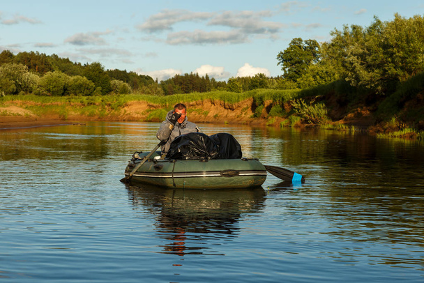 Bir adam Pizhma Nehri 'nde kauçuk bir teknede yüzüyor. - Fotoğraf, Görsel