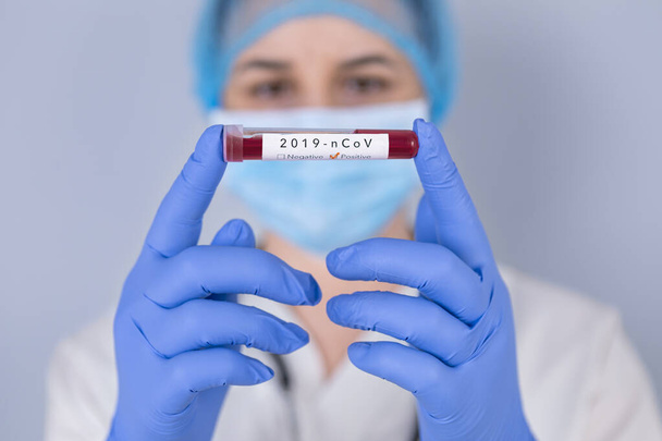 Медсестра держит пробирку с положительным анализом коронавируса крови Сэма
 - Фото, изображение