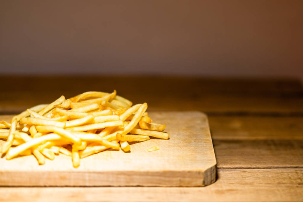 French fries on a wooden table. Food, junk food and fast food co - Fotografie, Obrázek