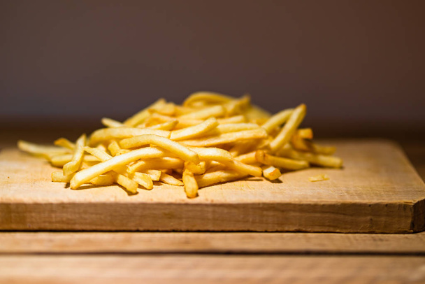 French fries on a wooden table. Food, junk food and fast food co - Photo, image