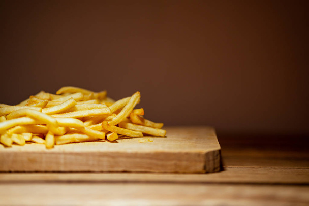 Papas fritas en una mesa de madera. Comida, comida chatarra y comida rápida co
 - Foto, Imagen