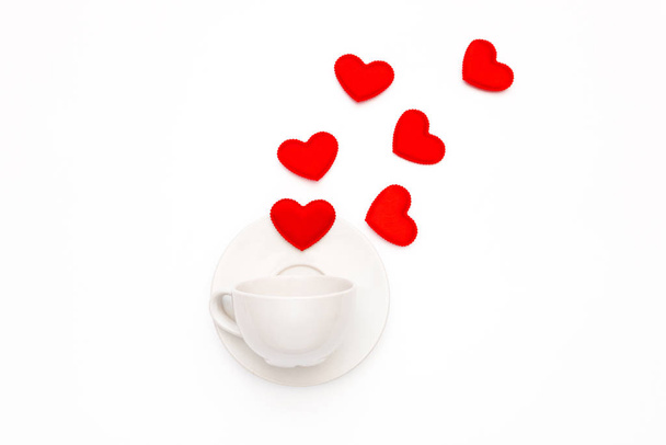 Top view of a white coffee Cup with a hearts on a white background. Greeting card for Valentine's Day - Фото, изображение