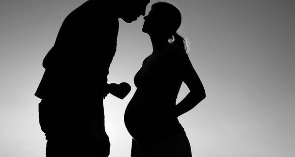 silhouette of a pregnant couple in love - Фото, зображення
