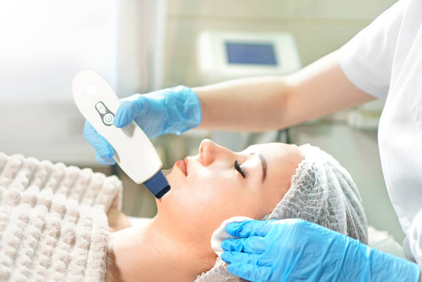 Cosmetologist doing ultrasound face peel for the young woman. Peeling close-up. - Photo, image