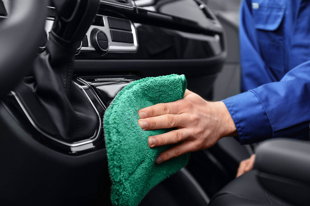 Car wash worker cleaning automobile interior, closeup - Foto, afbeelding