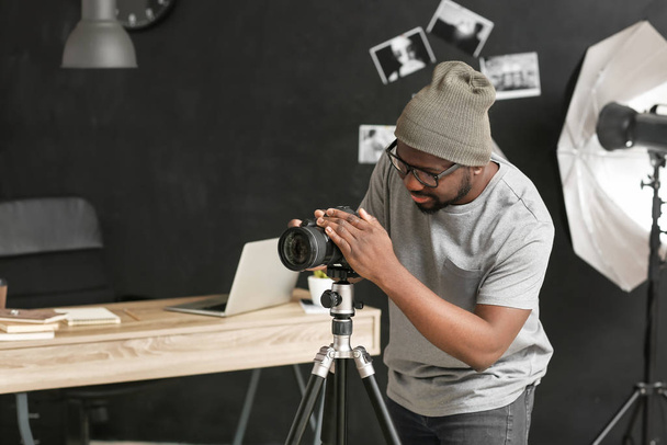 スタジオでカメラを持つアフリカ系アメリカ人の写真家 - 写真・画像