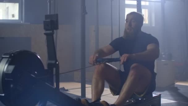 Rowing in the gym. Young man training using rowing machine. slow motion. - Footage, Video