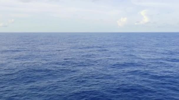 uitzicht op het schip van de open eindeloze blauwe oceaan, rustige zee, met de lucht boven de horizon - Video
