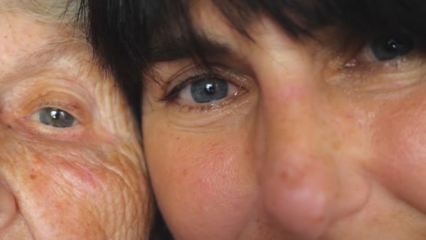 Eyes of elderly woman and her adult daughter looking into camera together. Old and young face. Detail view Slow motion Close up - 映像、動画