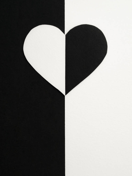 Walentynki. Koncepcja. Walentynki: połówki czarno-białego serca na czarno-białym papierowym tle. Widok góry. Przestrzeń kopiowania - Zdjęcie, obraz