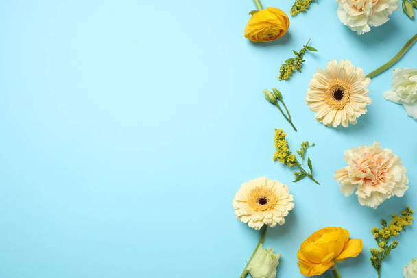 Floral composition with beautiful flowers on light blue background, flat lay. Space for text - Foto, imagen