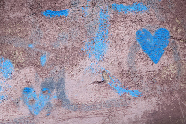 Oude muur met verfvlekken, abstracte textuur achtergrond. Bourgogne, grijs, bruin, blauwe kleuren, verloop. Blauwe harten - Foto, afbeelding