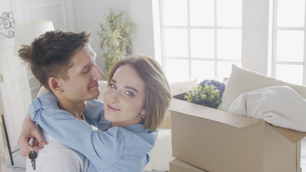 Šťastný pár poprvé kupující majitelé domů objímající slaví stěhování den - Záběry, video