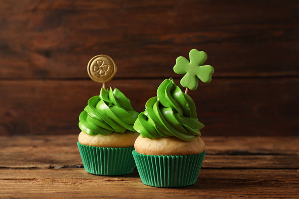 Delicious decorated cupcakes on wooden table. St. Patrick's Day celebration - Fotó, kép