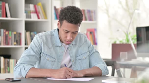 Στρεσαρισμένος νεαρός Αφροαμερικανός που απέτυχε να γράψει σε χαρτί  - Πλάνα, βίντεο