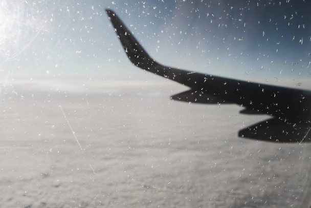 View of the morning winter sky through a frozen window of an airplane. Aerial background with a copy space - Photo, Image