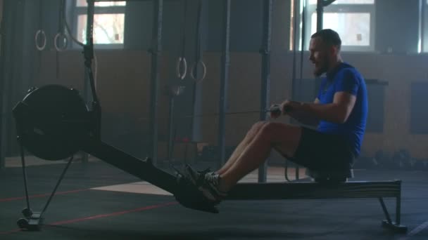 Zpomalení muži trénink veslování v tělocvičně s posilovacími stroji a táhnout lano - Záběry, video