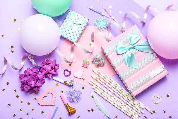Fondo colorido de la celebración con varios confeti de fiesta, globos, regalos y decoración sobre fondo lila
. - Foto, Imagen