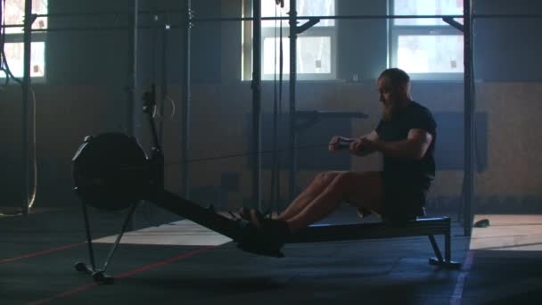fitness muž atlet trénink veslování stroj cvičení intenzivní vytrvalost cvičení výzva silný sportovec fyzická praxe v tělocvičně zdravý životní styl motivace zblízka ruce. zpomalený pohyb - Záběry, video