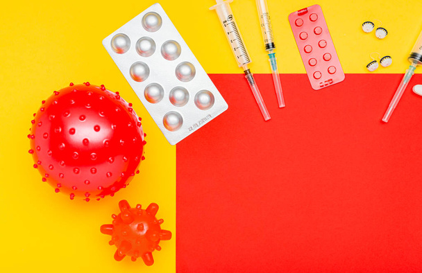 Different drugs, medicines tablets syringes against coronavirus, blood cancer, leukemia. Copy space on red, yellow background. Chinese Coronavirus, WUHAN virus, Coronavirus outbreak, influenza. - 写真・画像