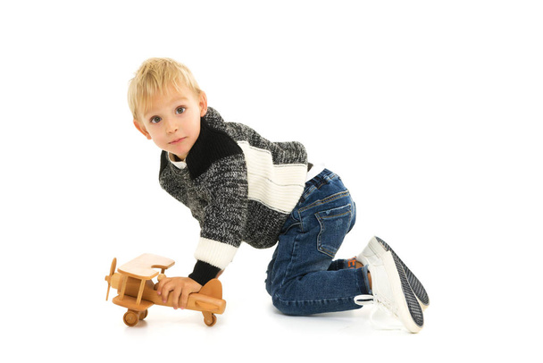 Little boy playing with wooden plane - Fotografie, Obrázek