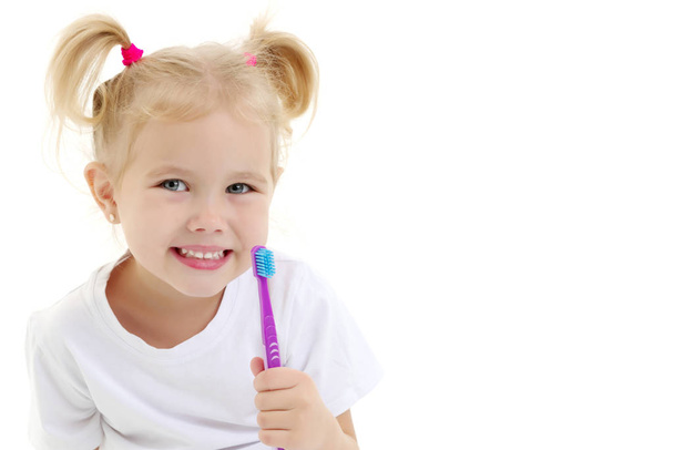 A little girl brushes her teeth. - Valokuva, kuva