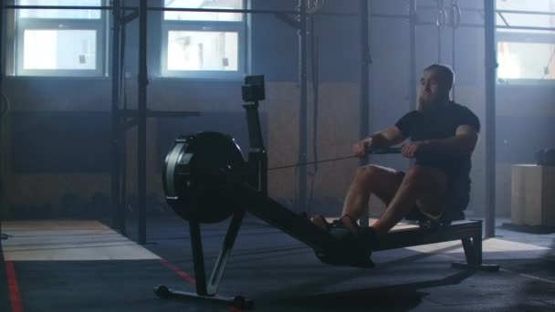 Wolno poruszający się mężczyźni trening wioślarski na siłowni z maszyn do ćwiczeń i ciągnąć liny - Materiał filmowy, wideo