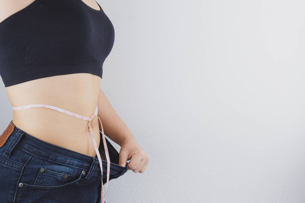 Крупним планом знімок жінки з тонким тілом, що показує її результати дієти
.  - Фото, зображення