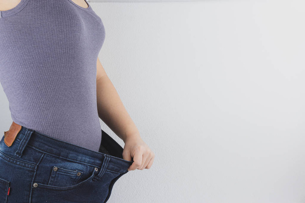 Primer plano de la mujer con el cuerpo delgado que muestra sus resultados de dieta
.  - Foto, imagen
