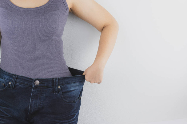 Primer plano de la mujer con el cuerpo delgado que muestra sus resultados de dieta
.  - Foto, Imagen