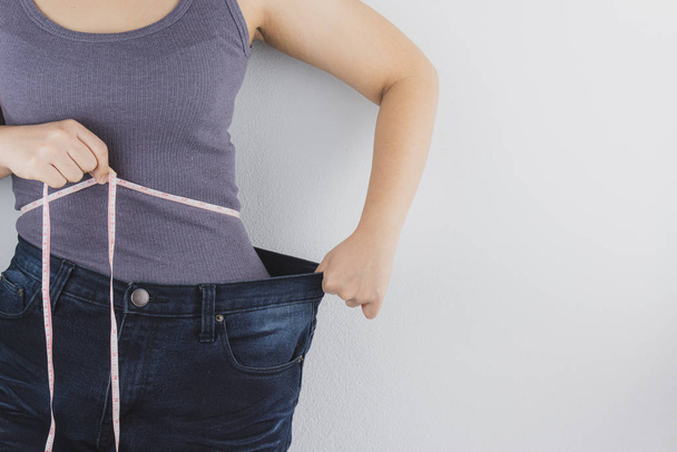 Close up shot of woman with slim body measuring her waistline an - Photo, Image