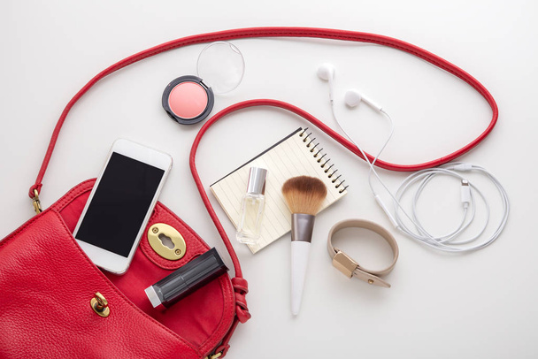 Bolso de moda mujer roja con cosméticos y accesorios
 - Foto, Imagen