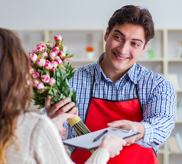 El asistente de la floristería vendiendo flores al cliente femenino - Foto, Imagen