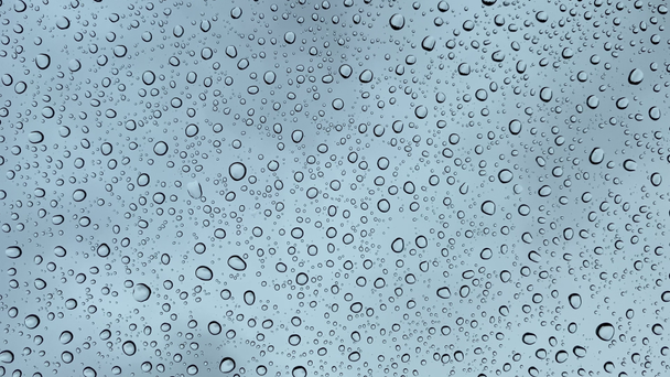 Detailní záběr kapek vody na sklenici, během deště. Velké kapky deště dopadají na okenní tabulku 4k. - Záběry, video