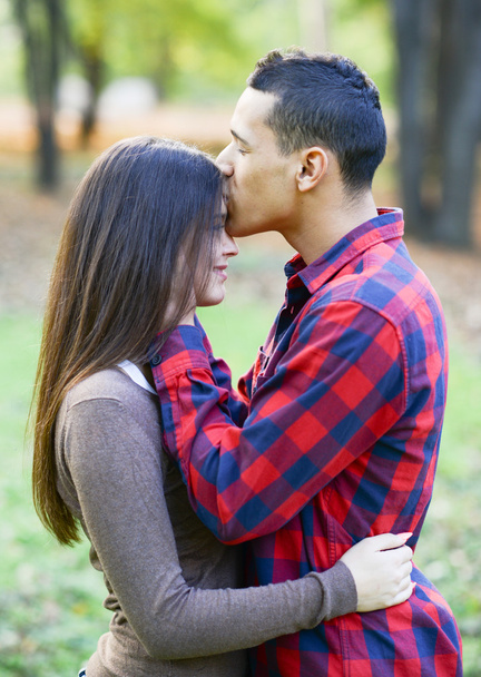 Primer plano de chico besando novia en la frente al aire libre
 - Foto, imagen