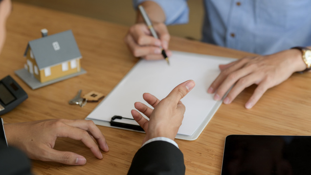 Обрезанный снимок агента по недвижимости, представляющего клиенту-мужчине при принятии решения подписать договор
 - Фото, изображение