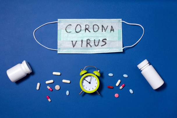 texto del coronavirus escrito en máscaras médicas y despertador
 - Foto, Imagen