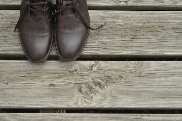 Dark brown boots on wooden floor - Foto, imagen