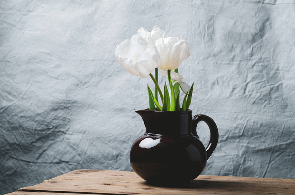 Tulip flowers in a ceramic vase on wooden table  with  space for text. - Fotó, kép