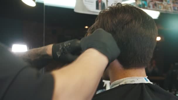 A man barber applying the shaving cream on hair edges for the finishing touches using the blades - Filmagem, Vídeo