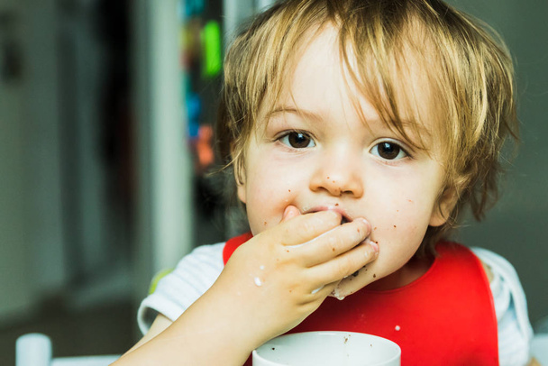 portrait adorable child eating chocolate sponge cake - Фото, зображення