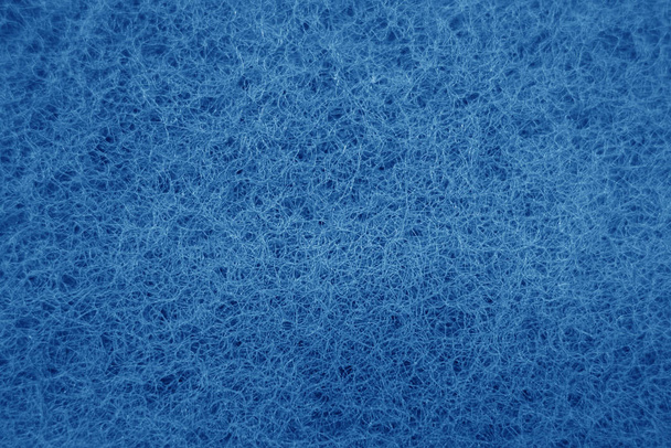 Cleaning sponge rubbing surface close up with blue effect in nav - 写真・画像
