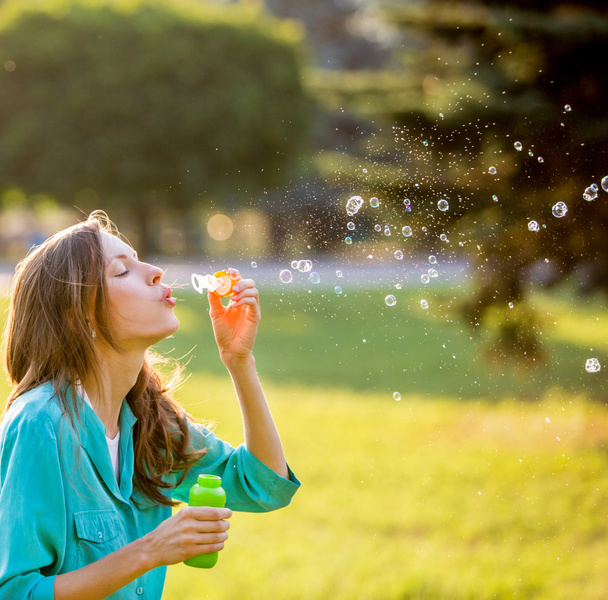 Beautiful woman blowing bubbles - Foto, imagen