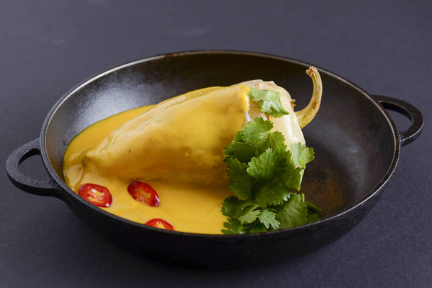 Paprika stuffed pepper with the minced meat and pumpkin sauce served in a pan over rustic wooden table. - Foto, Imagen