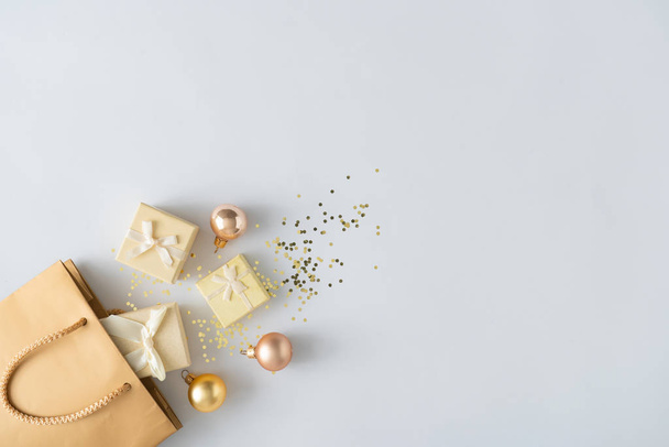 Gift shopping bag with presents and Christmas balls with golden glitter. Holiday sale concept  - Fotoğraf, Görsel