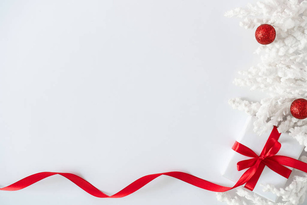 Natale e Capodanno sfondo vacanza con scatola regalo e nastro rosso con bagattelle e rami innevati
  - Foto, immagini