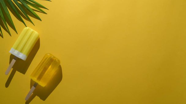 Limon aromalı dondurma, fotokopi alanı ve sarı arka planda palmiye yaprağı içeren renkli minimal yaz kavramının en üst görünümü  - Fotoğraf, Görsel
