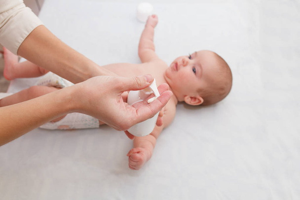 Masseuse massaging little baby, squeezes cream. hypertonicity correction - Fotografie, Obrázek