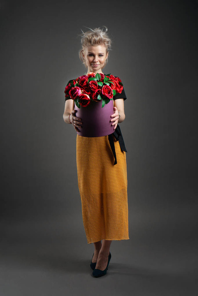 Portrait of a beautiful young blonde caucasian woman with basket of flowers - Fotó, kép