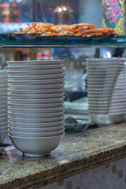 Pile of white bowl inside kitchen counter in food court - Photo, Image
